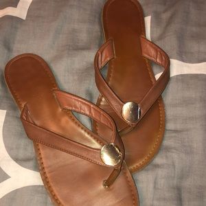 Tan and gold flip flops